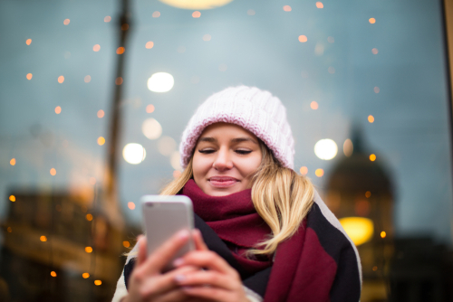 Hipster,Girl,In,Fashionable,Knitted,Hat,Using,Applications,On,Mobile